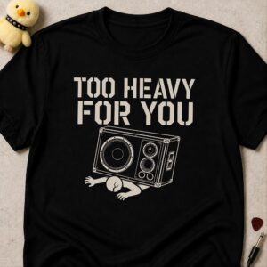Black t-shirt printed TOO HEAVY FOR YOU above a person pinned flat under a fallen speaker cabinet