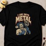 Black t-shirt printed I AM INTO METAL above a grinning scientist holding a lump of iron ore in tongs