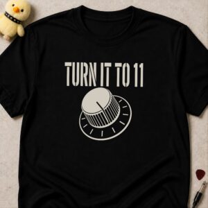 Black t-shirt printed TURN IT TO 11 above an amplifier knob turned past the last mark