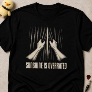Black t-shirt printed SUNSHINE IS OVERRATED below two hands pulling a pair of curtains shut