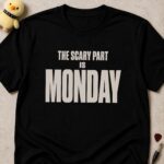 Black t-shirt printed THE SCARY PART IS MONDAY in bold condensed white lettering