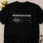 Black t-shirt printed SCREAMING HELPS ME FOCUS above a jagged waveform settling into a flat line