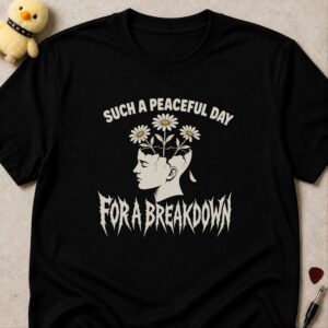 Black t-shirt printed SUCH A PEACEFUL DAY FOR A BREAKDOWN around a cracked classical head with daisies growing out of it