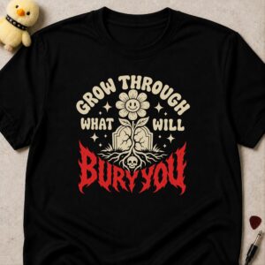 Black t-shirt printed GROW THROUGH WHAT WILL BURY YOU around a smiling flower growing from a gravestone, BURY YOU in dripping red letters